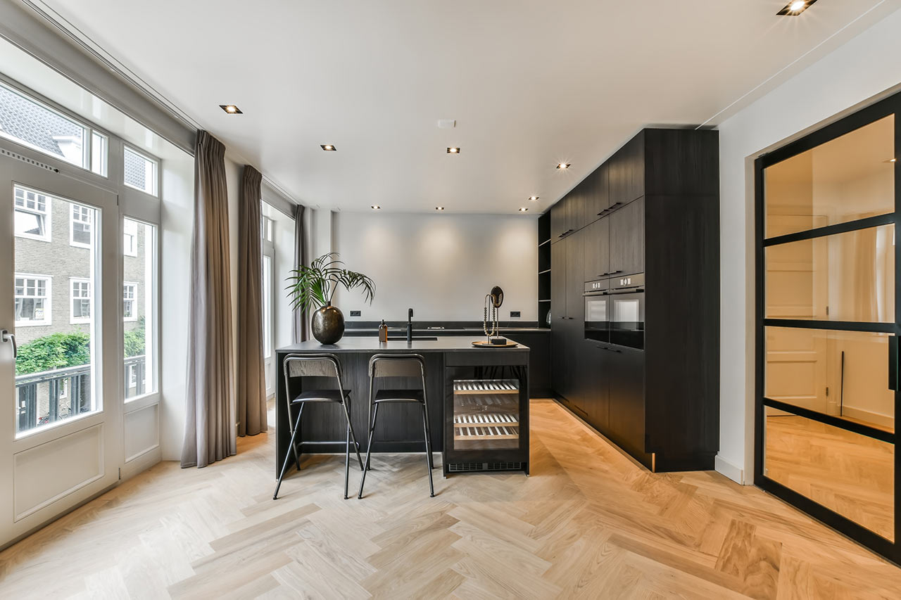 Strohá krása – černý kuchyňský nábytek, bílá výmalba, dřevěná podlaha 