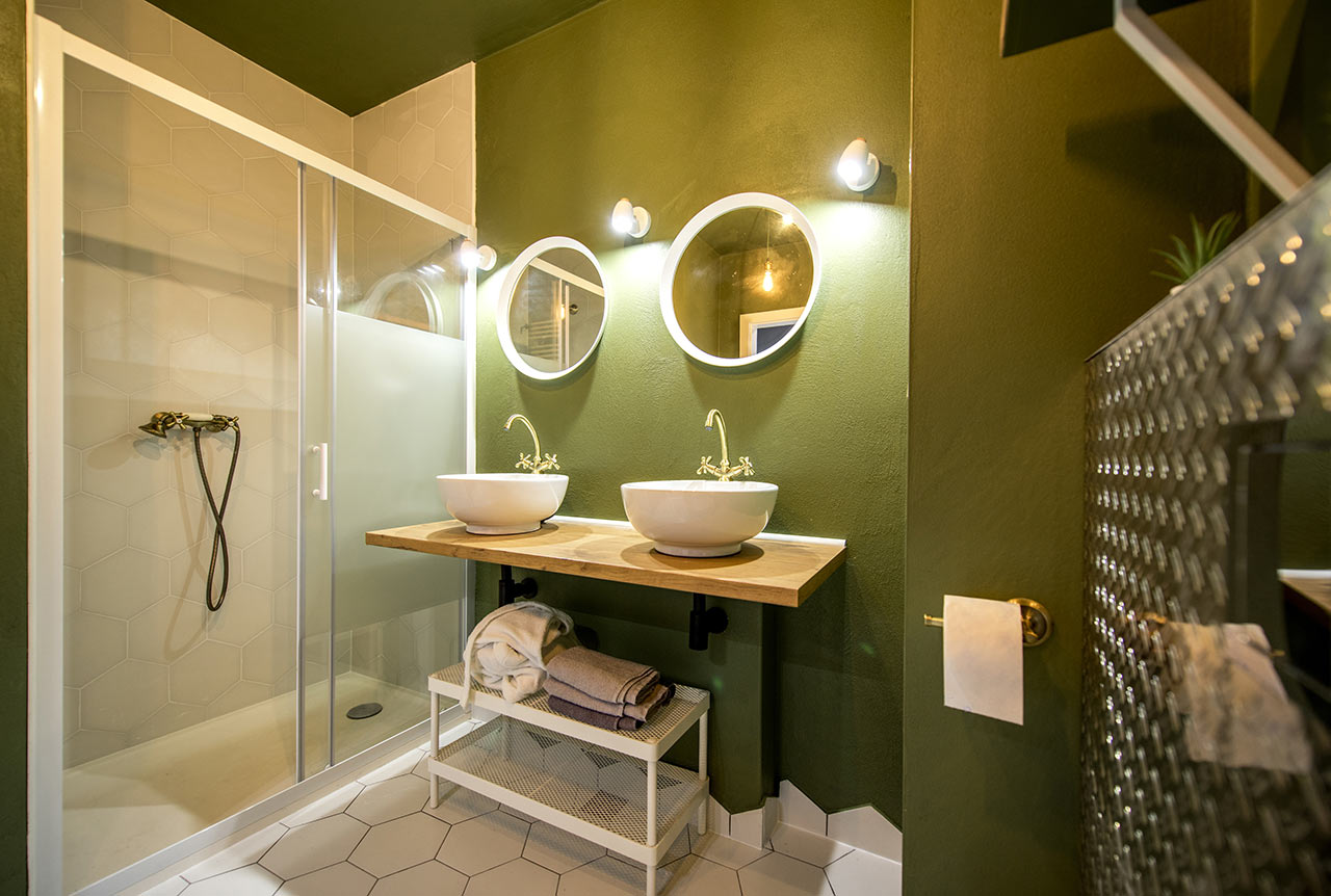 Barevná koupelna se zelenou stěnou a šestiúhelníkovými kachličkami na podlaze