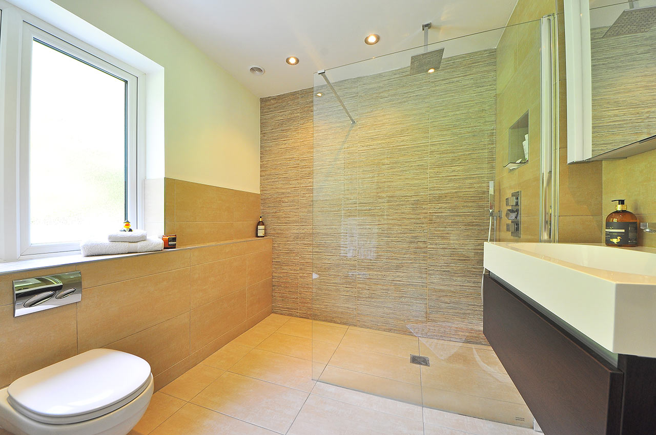 Moderní koupelna s walk-in sprchovým koutem za čirou skleněnou zástěnou