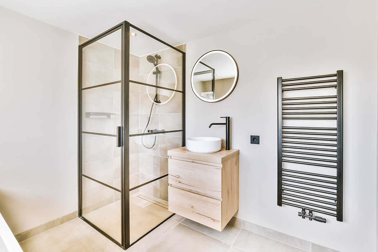 Moderní minimalistická koupelna s walk-in sprchovým koutem krytým rámovanou skleněnou zástěnou