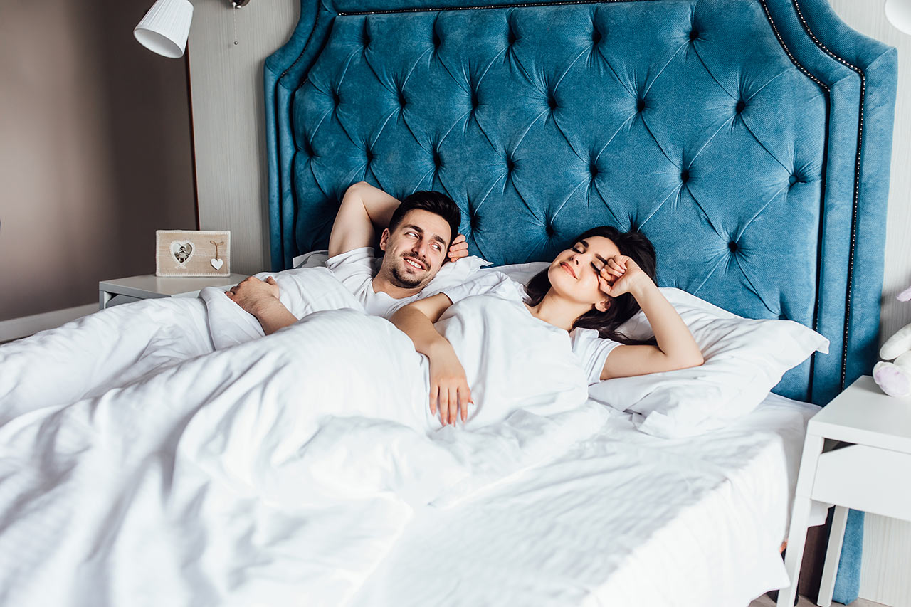 Šťastný mladý pár v manželské posteli v pohodlí
