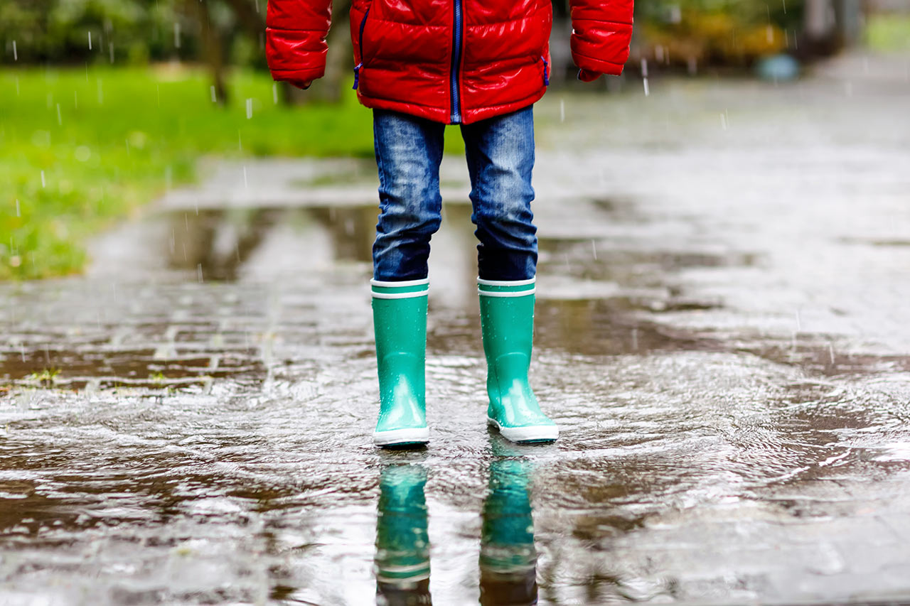 Dítě v gumácích si užívá deštivé počasí