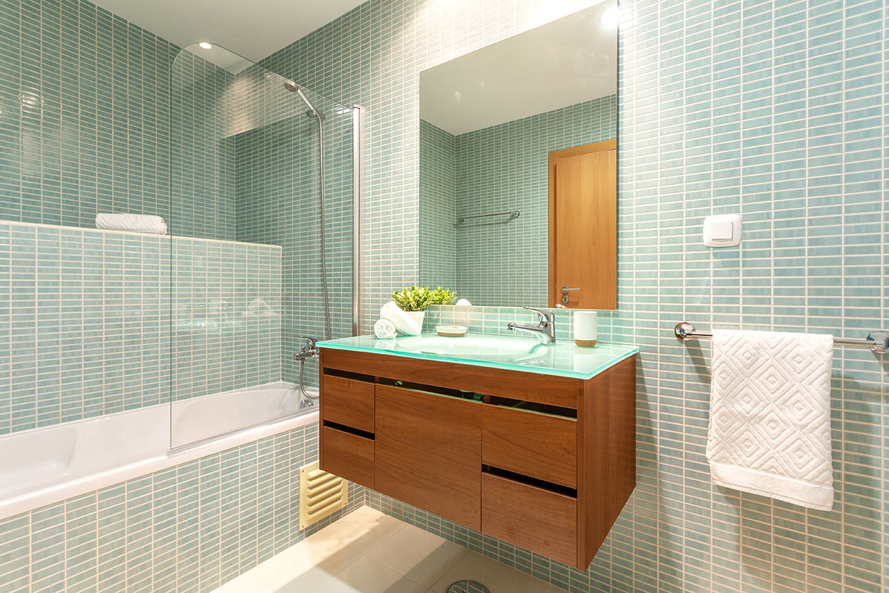 Moderní koupelna s akvamarínovými kachličkami a skříňkou navěšenou na stěně
