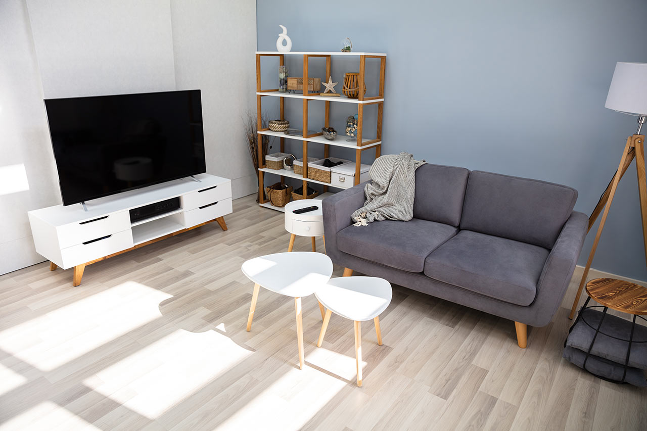Moderní obývací pokoj ve světlém provedení s výraznou plochou televizí na skříňce