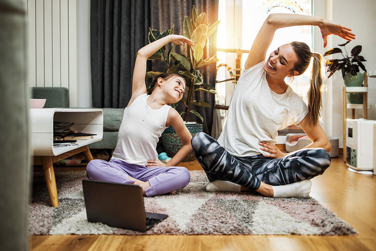 Matka s dcerou spokojeně cvičí jógu v harmonicky zařízeném obýváku