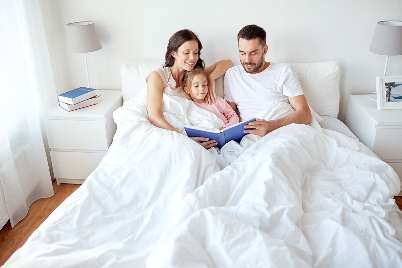Spokojená rodina v malé ložnici čte knihu
