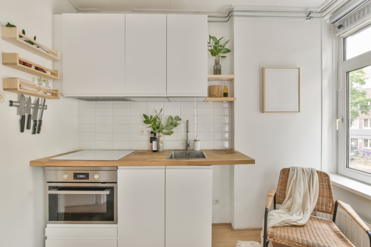 Dřevěná podlaha a světlá kuchyňská linka navodí iluzi většího prostoru