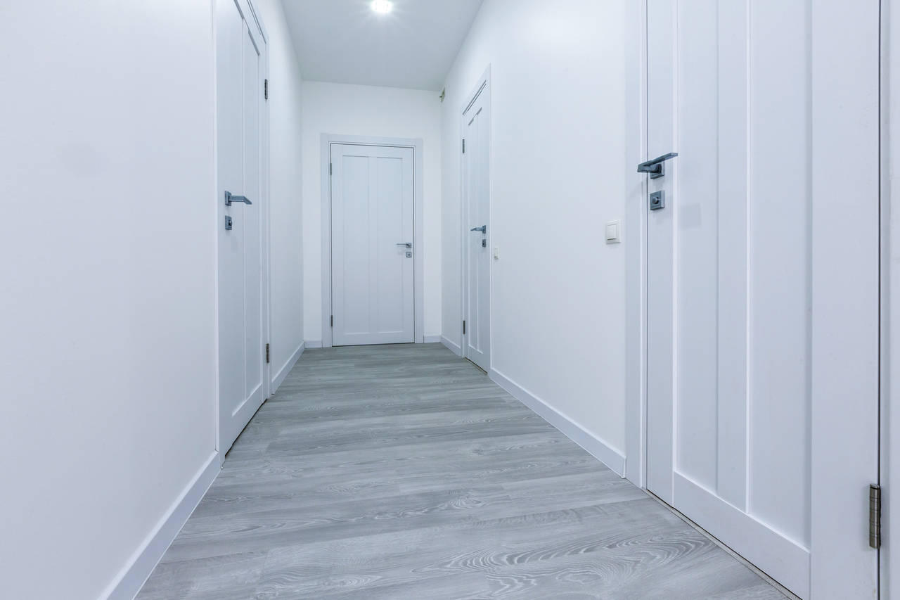 Nezapomínejte na kontext okolí. Světlá chodba je lepší volbou. Většinou nemá okna. Bílé stěny a dveře dobře odrážejí světlo a místnost opticky působí vzdušnější a větší.